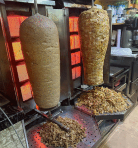 Parrillas de carne döner girando al fuego en el Bar Doner Kebab Said, Les Roquetes del Garraf.