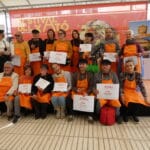 Grupo de participantes del Concurso Nacional de Xató Pere Tàpias 2025 posando con diplomas en el Mercado de Mar de Vilanova i la Geltrú